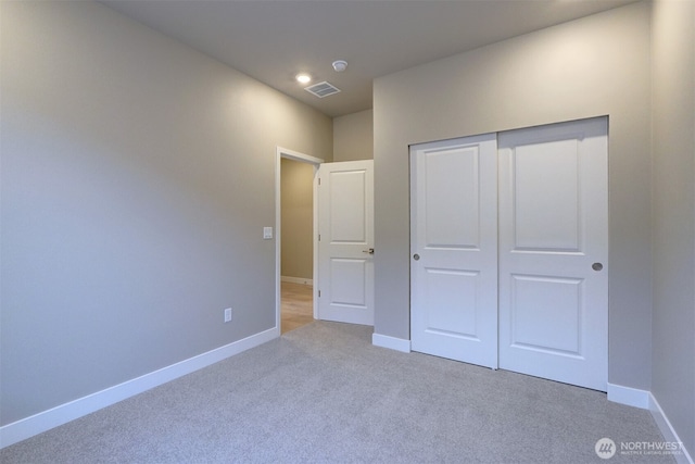 unfurnished bedroom featuring visible vents, carpet, baseboards, and a closet