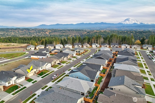 aerial view with a residential view, a view of trees, and a mountain view