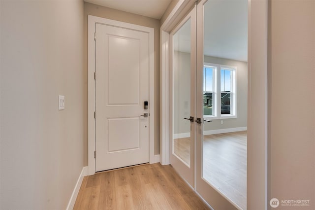 doorway to outside with baseboards and light wood-style flooring