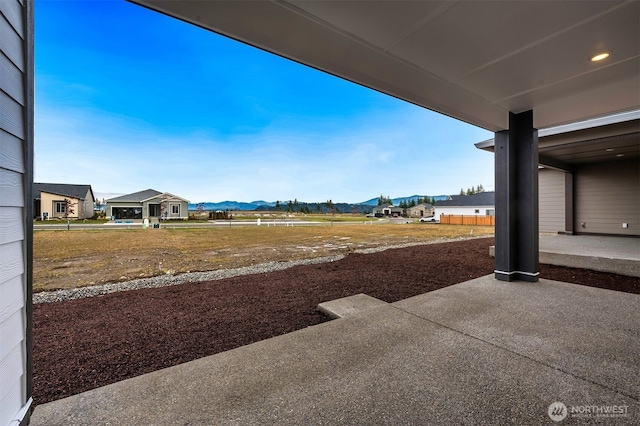 view of yard featuring a patio and a mountain view