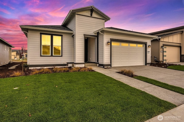 view of front facade with a lawn, an attached garage, driveway, and board and batten siding