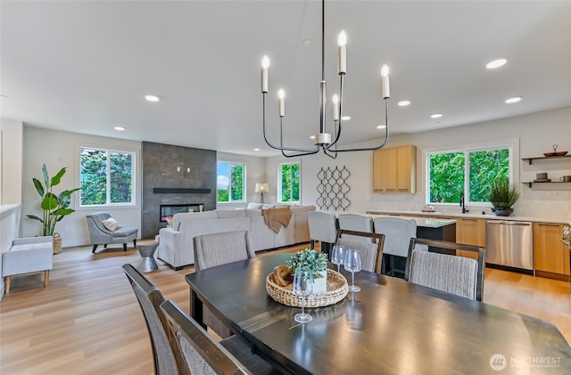 dining room with healthy amount of natural light, recessed lighting, light wood finished floors, and a fireplace
