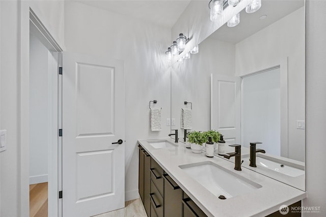 full bathroom with double vanity and baseboards