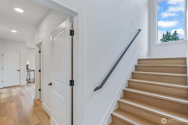 stairway featuring wood finished floors, recessed lighting, and baseboards