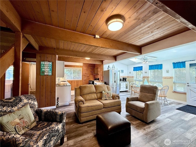living room with ceiling fan, wood-type flooring, baseboards, wooden ceiling, and beamed ceiling