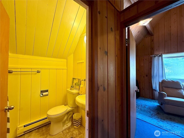 bathroom with wood walls, baseboard heating, vaulted ceiling, and toilet