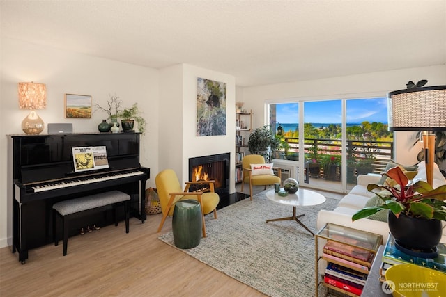 living room with a fireplace with flush hearth and wood finished floors