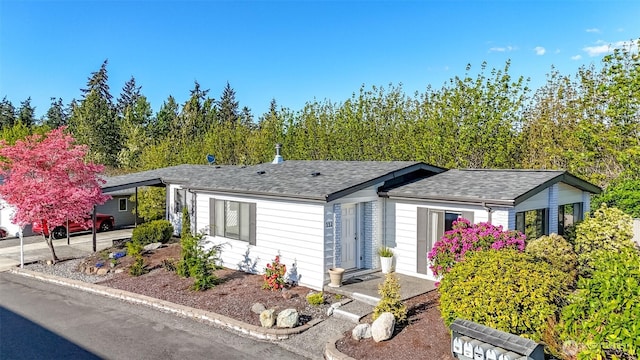 ranch-style home featuring roof with shingles