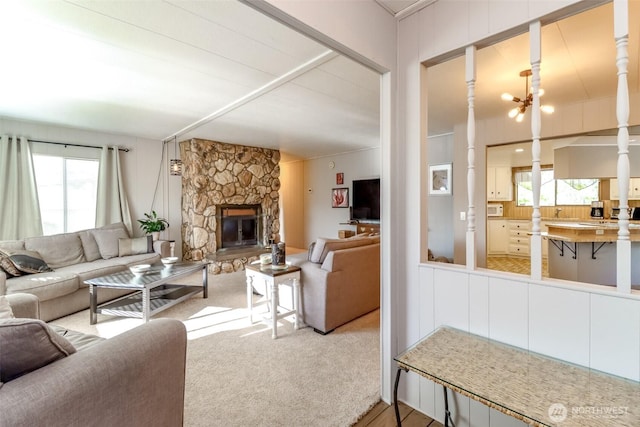 living area with a stone fireplace and plenty of natural light