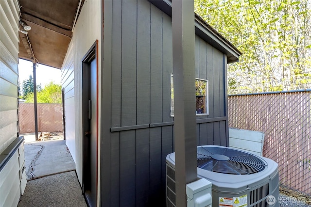 view of outbuilding with central AC unit and fence