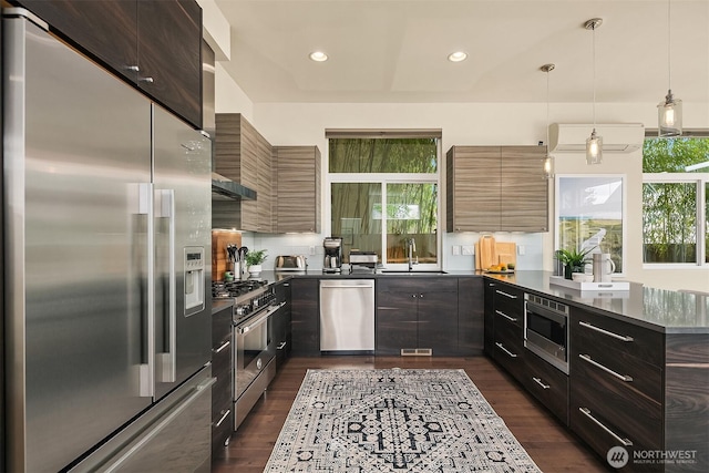 kitchen featuring modern cabinets, high quality appliances, dark wood-type flooring, recessed lighting, and a sink