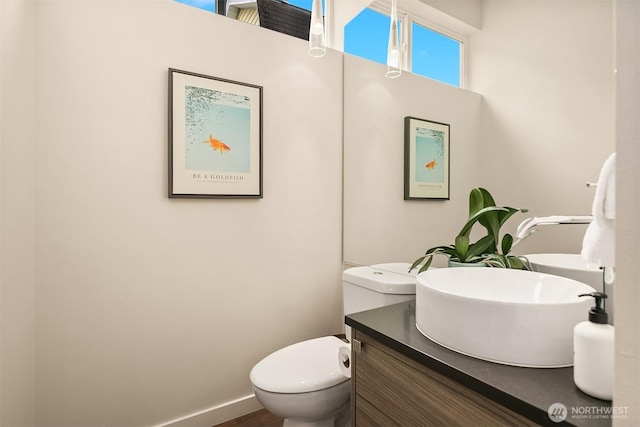 half bathroom featuring vanity and toilet