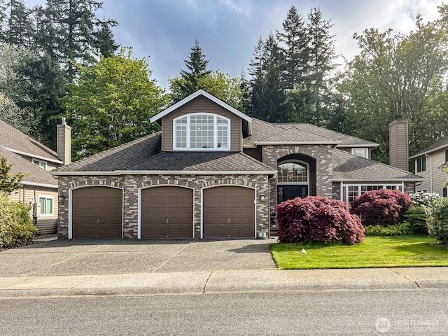 view of front of property featuring roof with shingles, an attached garage, brick siding, and aphalt driveway