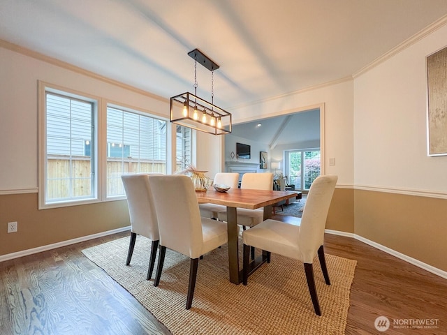 dining area featuring baseboards, ornamental molding, and wood finished floors