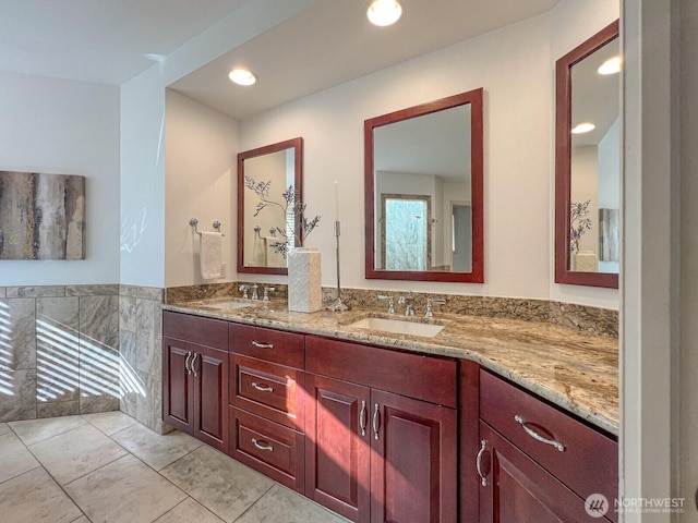 full bath featuring double vanity, recessed lighting, and a sink