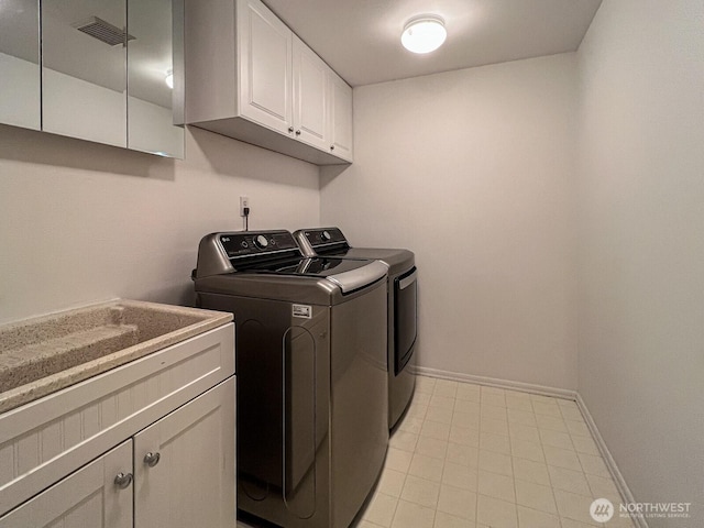 laundry room featuring visible vents, washing machine and clothes dryer, cabinet space, baseboards, and light tile patterned flooring