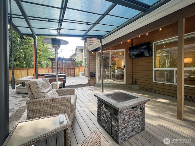 deck featuring a hot tub, fence, a pergola, and visible vents