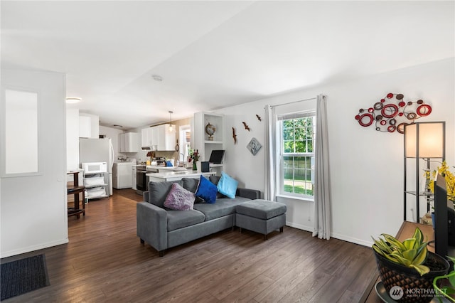 20323 Jordan Rd, Arlington, WA 98223 - living area featuring dark wood-style floors, vaulted ceiling, and baseboards