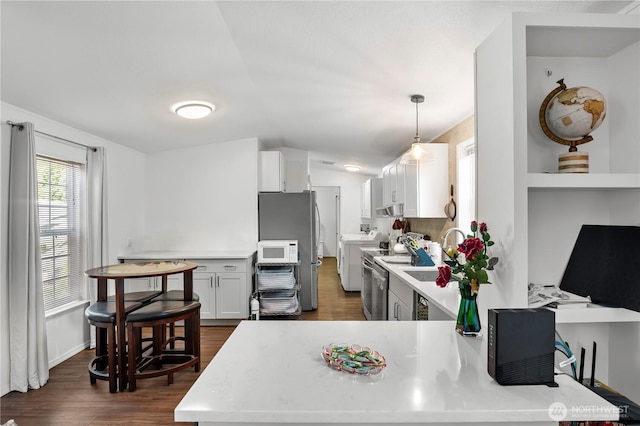 20323 Jordan Rd, Arlington, WA 98223 - kitchen with white microwave, light countertops, dark wood finished floors, lofted ceiling, and white cabinets