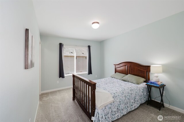bedroom featuring baseboards and light carpet