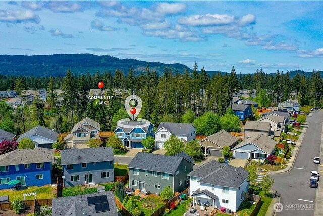 birds eye view of property featuring a forest view, a residential view, and a mountain view