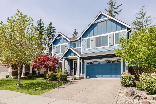 craftsman-style house featuring roof with shingles, an attached garage, a front lawn, board and batten siding, and concrete driveway