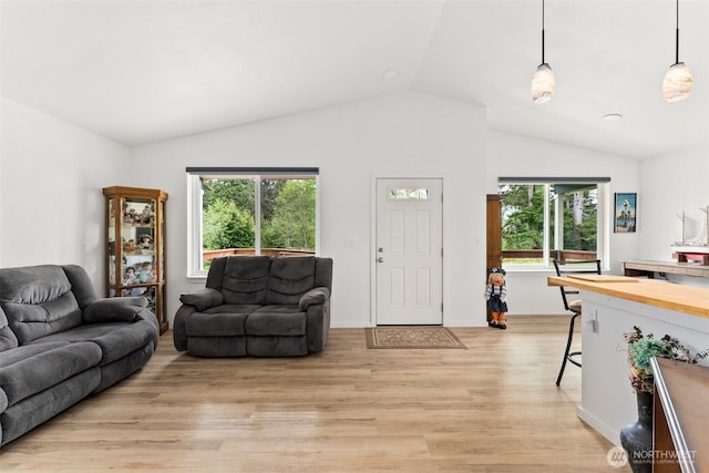 living area with light wood-style flooring and lofted ceiling