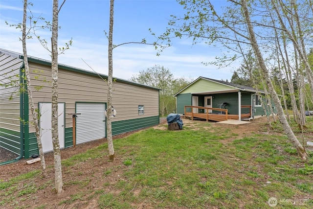 exterior space with a garage, a wooden deck, and a yard