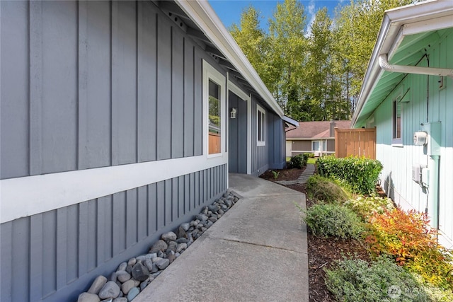 view of property exterior with board and batten siding and fence
