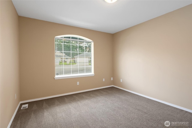 spare room featuring baseboards, carpet, and visible vents