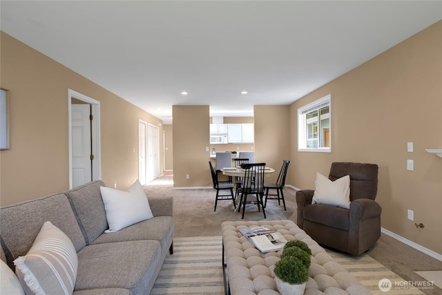 living area featuring baseboards, light carpet, and recessed lighting