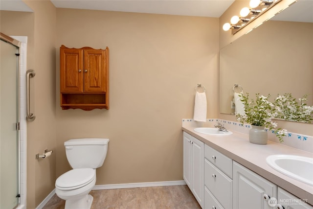 full bathroom with double vanity, toilet, a shower with door, and a sink