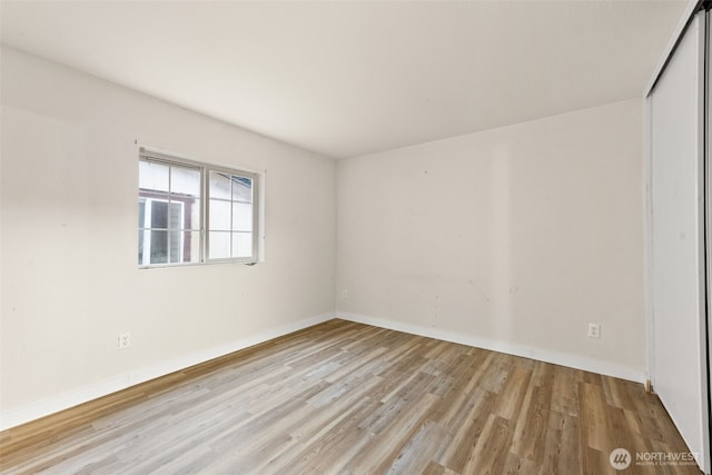 unfurnished room featuring baseboards and wood finished floors