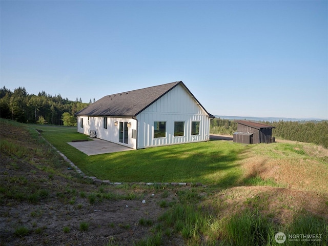 159 Bootjack Ln, Kelso, WA 98626 - rear view of house featuring roof with shingles, a patio, board and batten siding, and a yard