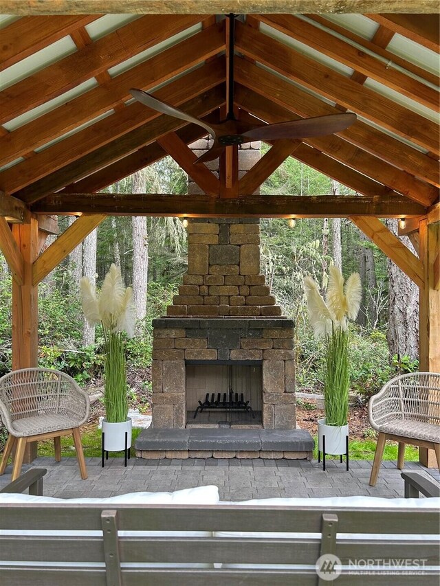 view of patio with a gazebo and an outdoor stone fireplace