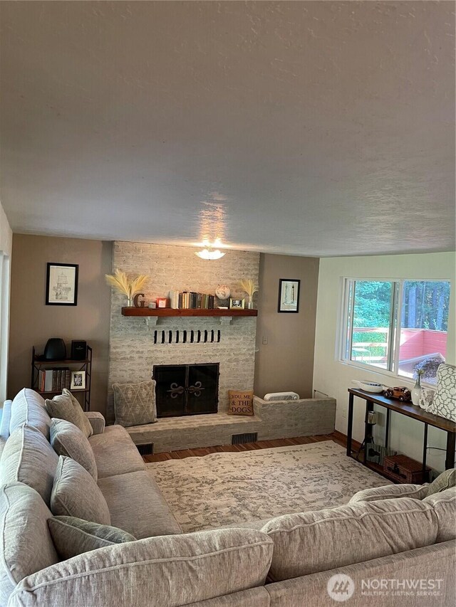 living area with baseboards, a fireplace, and visible vents