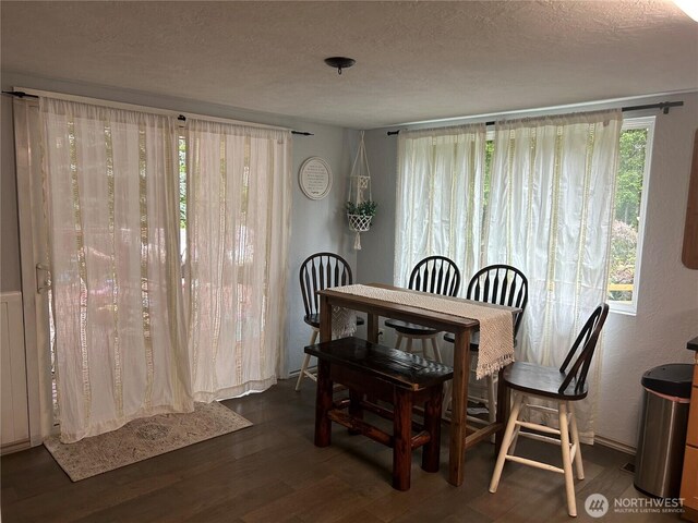 dining area with a textured ceiling and wood finished floors