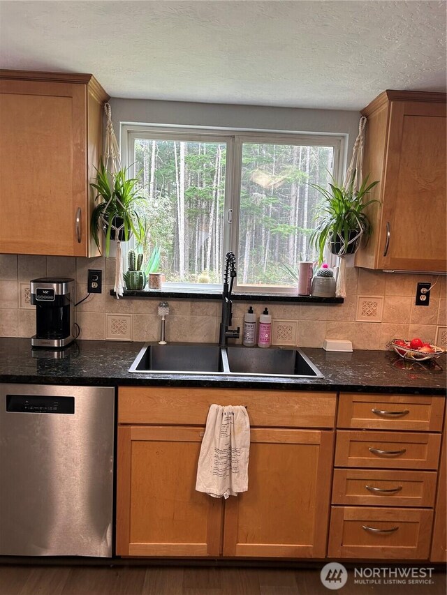 kitchen featuring a sink, plenty of natural light, backsplash, and dishwasher