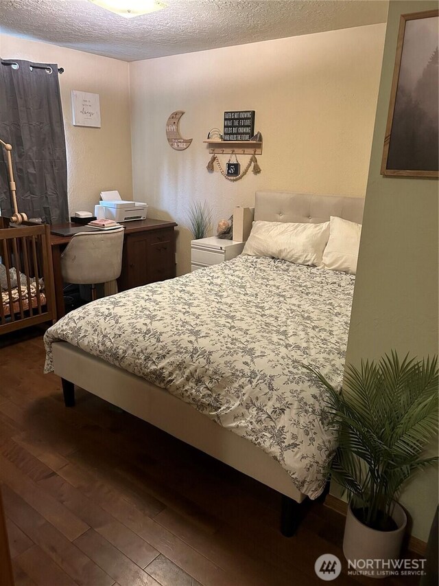 bedroom featuring wood-type flooring and a textured ceiling