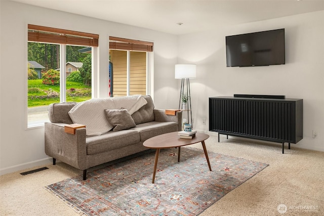 carpeted living area with baseboards