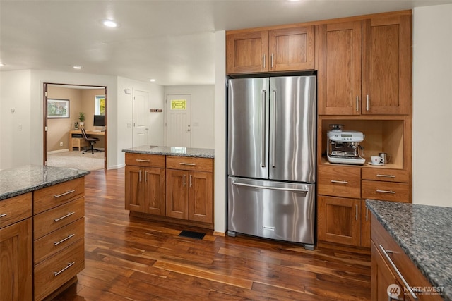 kitchen with recessed lighting, freestanding refrigerator, dark wood-style flooring, and brown cabinets