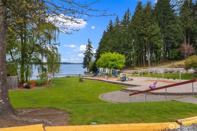 view of home's community with a water view, a yard, and playground community