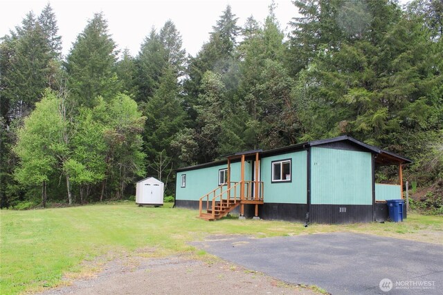 manufactured / mobile home featuring an outbuilding, a shed, and a front yard