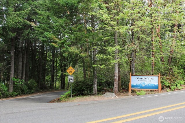 view of street with traffic signs and a forest view