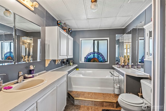 full bath with toilet, a garden tub, and vanity
