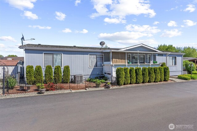 manufactured / mobile home with central AC unit and fence