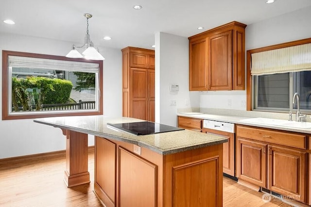 kitchen with light wood-style floors, a sink, dishwashing machine, and black electric stovetop