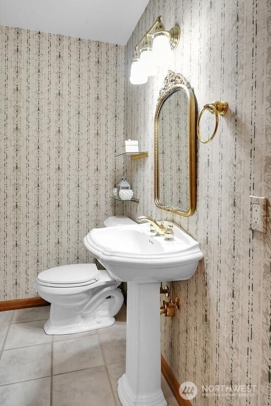 bathroom featuring tile patterned flooring, toilet, and wallpapered walls