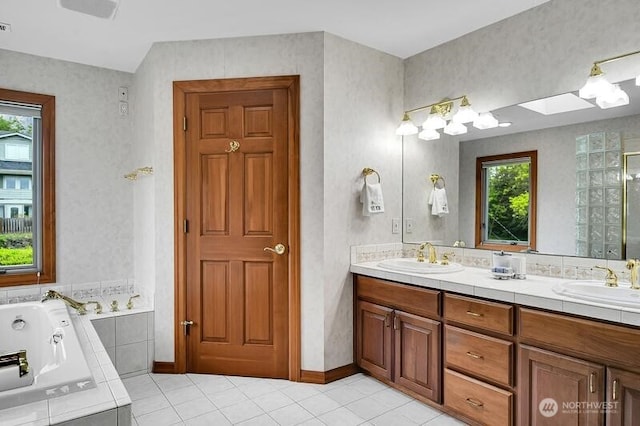 full bath with a tub with jets, a sink, tile patterned floors, and double vanity