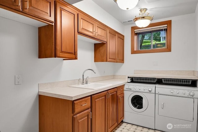 clothes washing area featuring visible vents, light floors, separate washer and dryer, a sink, and cabinet space